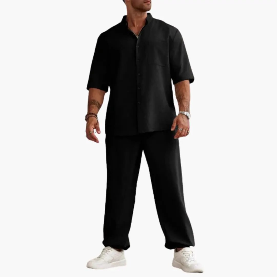 Men's black short-sleeve shirt and long black pants set with white sneakers.