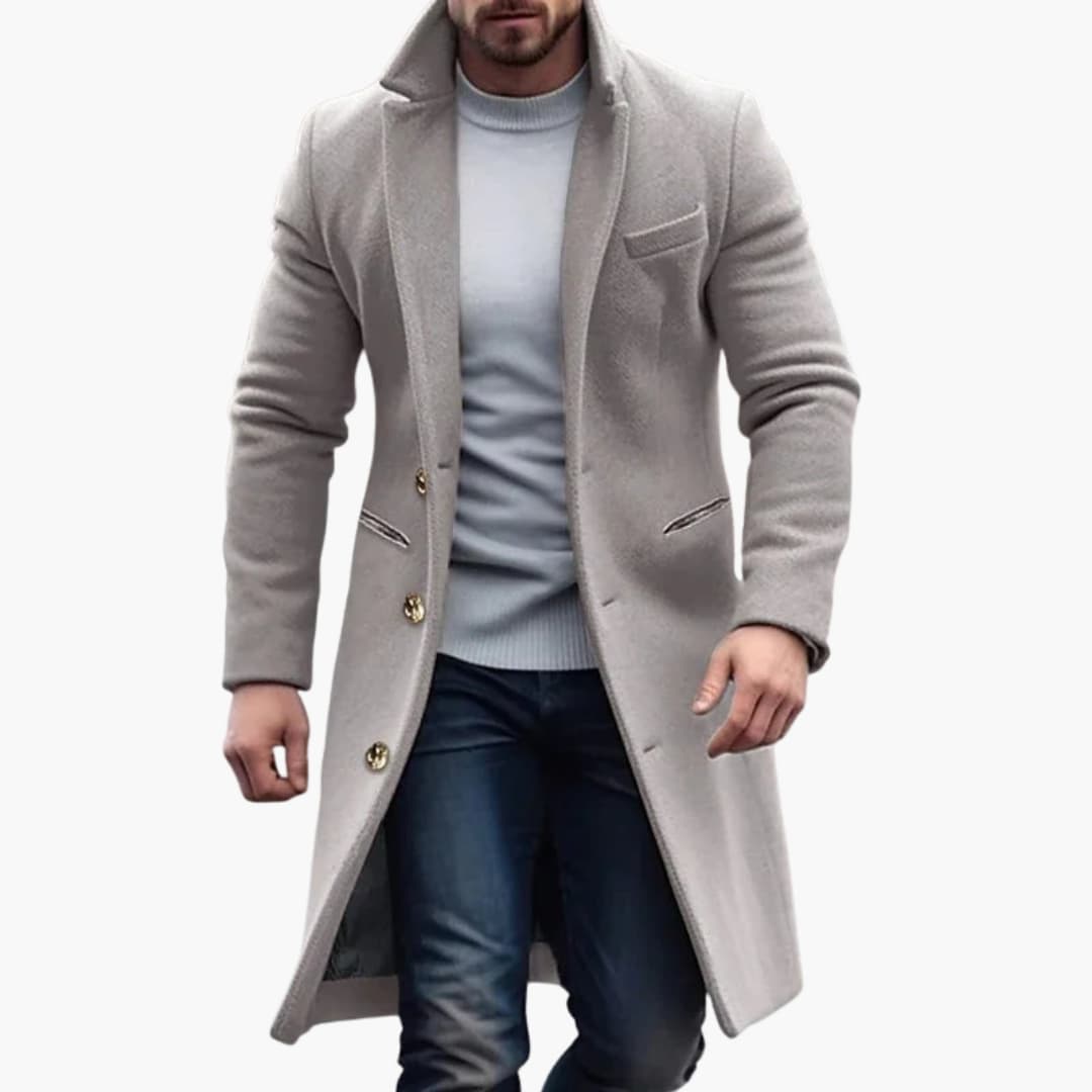 Men's long coat with notched lapel and button closure, beige, worn by a man.