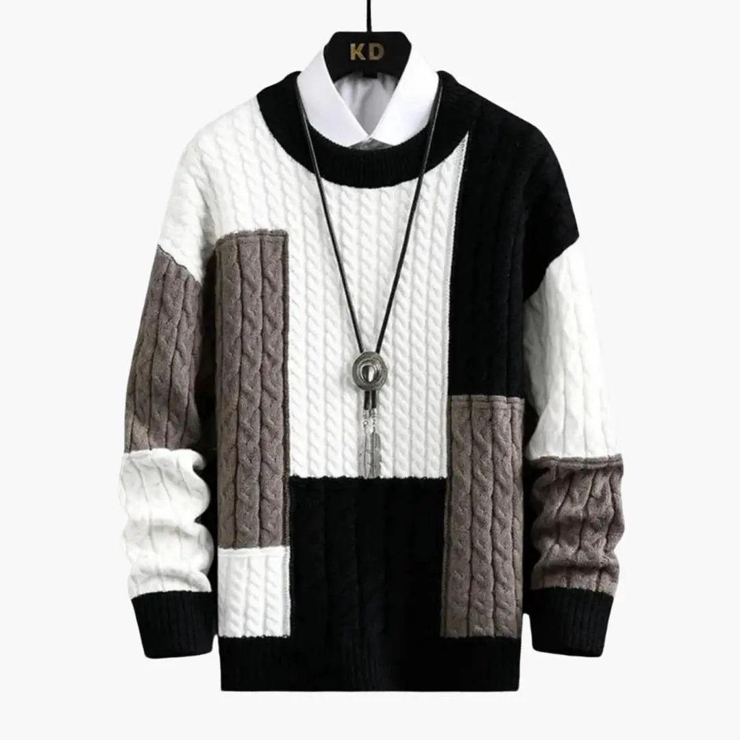 Men's round-neck patchwork cable-knit sweater with white, black and gray panels.