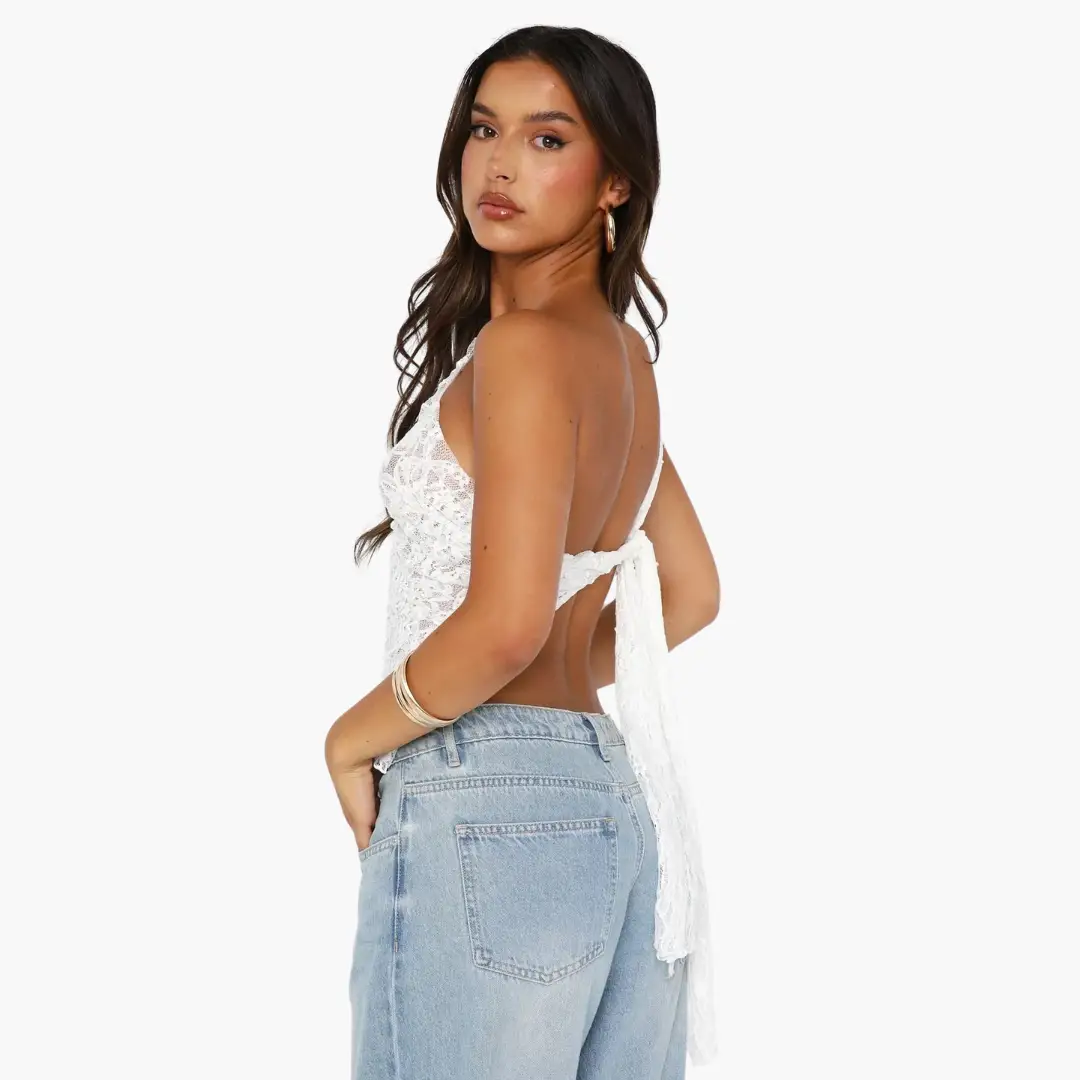 Lace one-shoulder top for women, white lace fabric with back-tie detail, shown with light-wash jeans