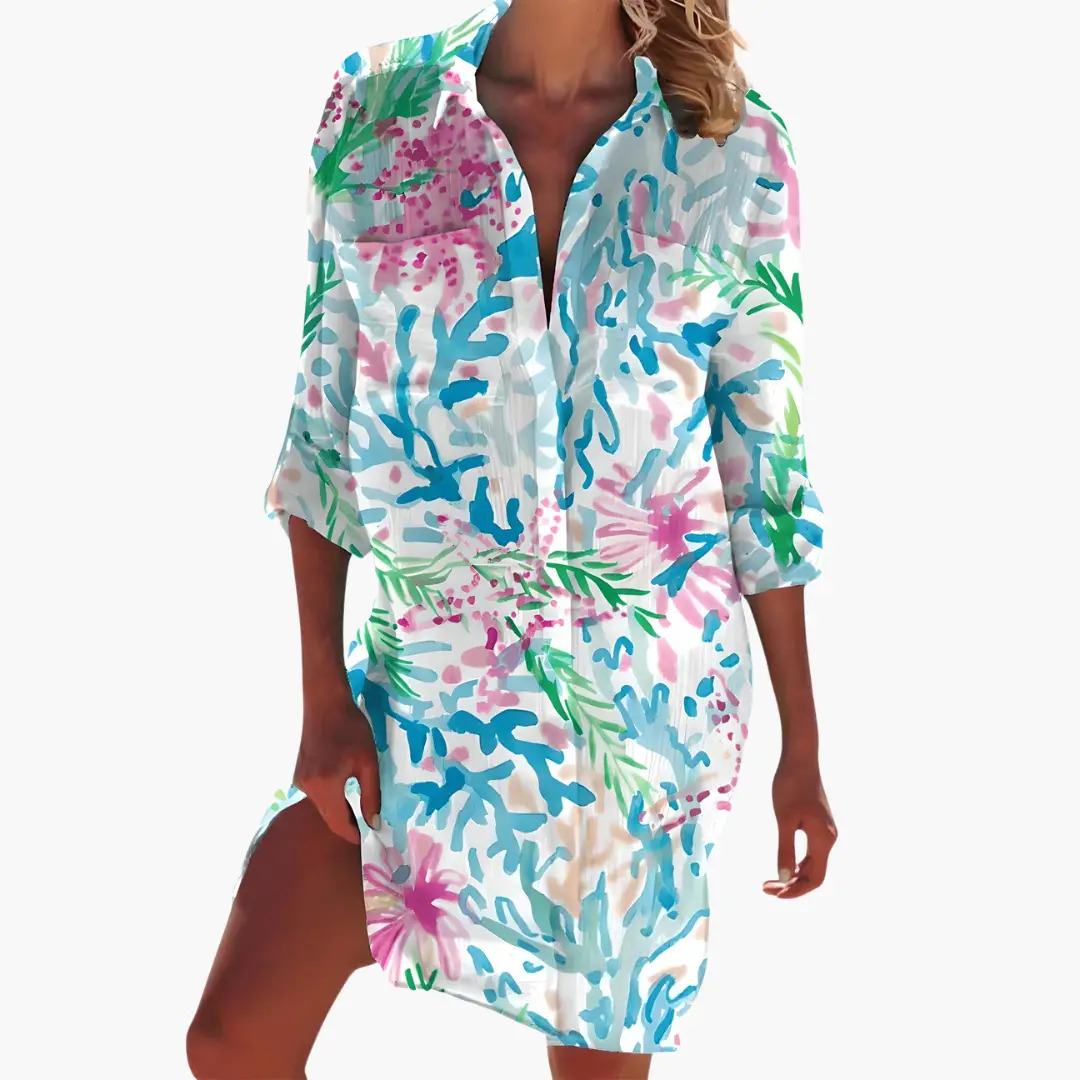 Women's shirt dress with long sleeves and button placket in bright abstract floral print in pink, blue, and green.