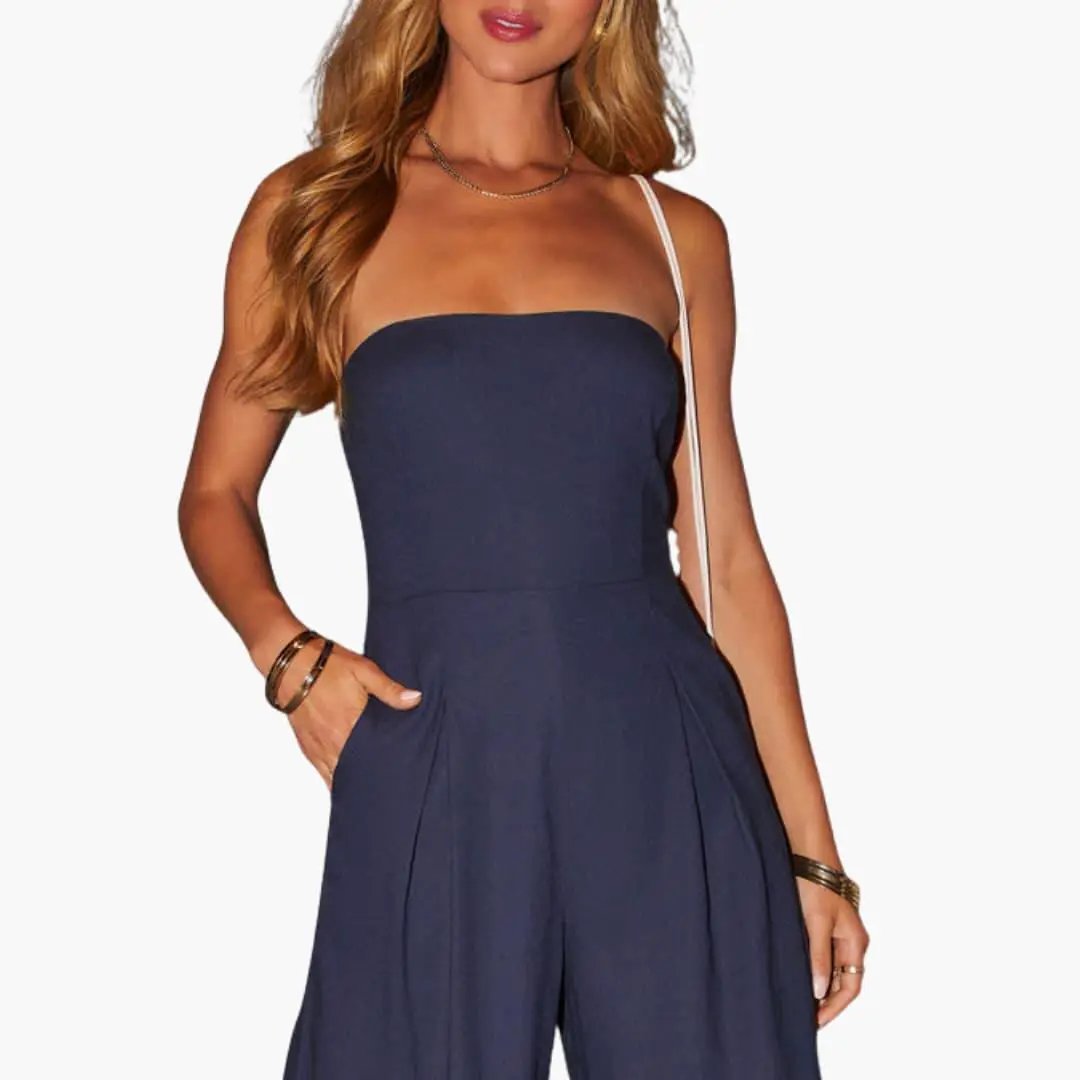 Jumpsuit for women in navy blue with a single white shoulder strap, pleated wide legs and side pockets