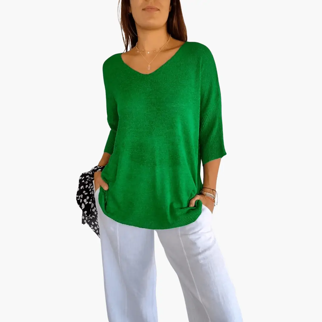 Women's green V-neck knit top, loose fit, with white pants and patterned scarf