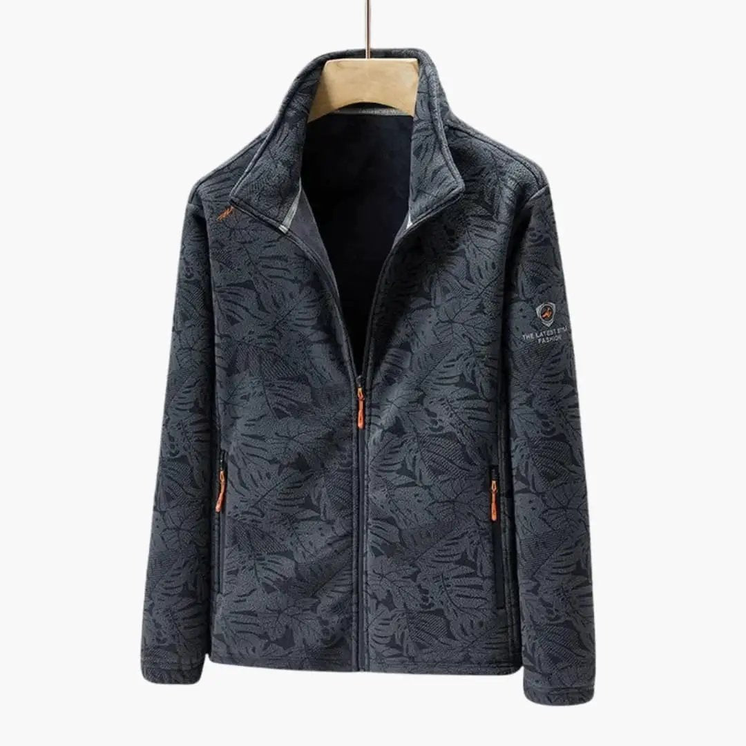 Unisex jacket with orange zipper pulls and side pockets in dark leaf-pattern fabric, stand-up collar, Wilfred Smith.