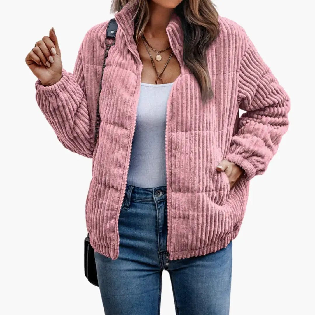 Women's pink ribbed jacket with zipper, worn over a light blue top.