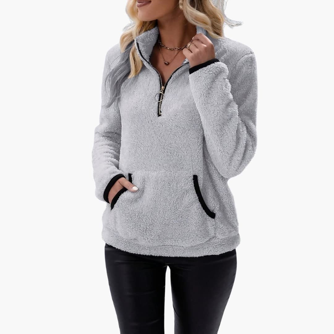 Women’s light gray fleece pullover with half-zip, black-trim pockets and cuffs.