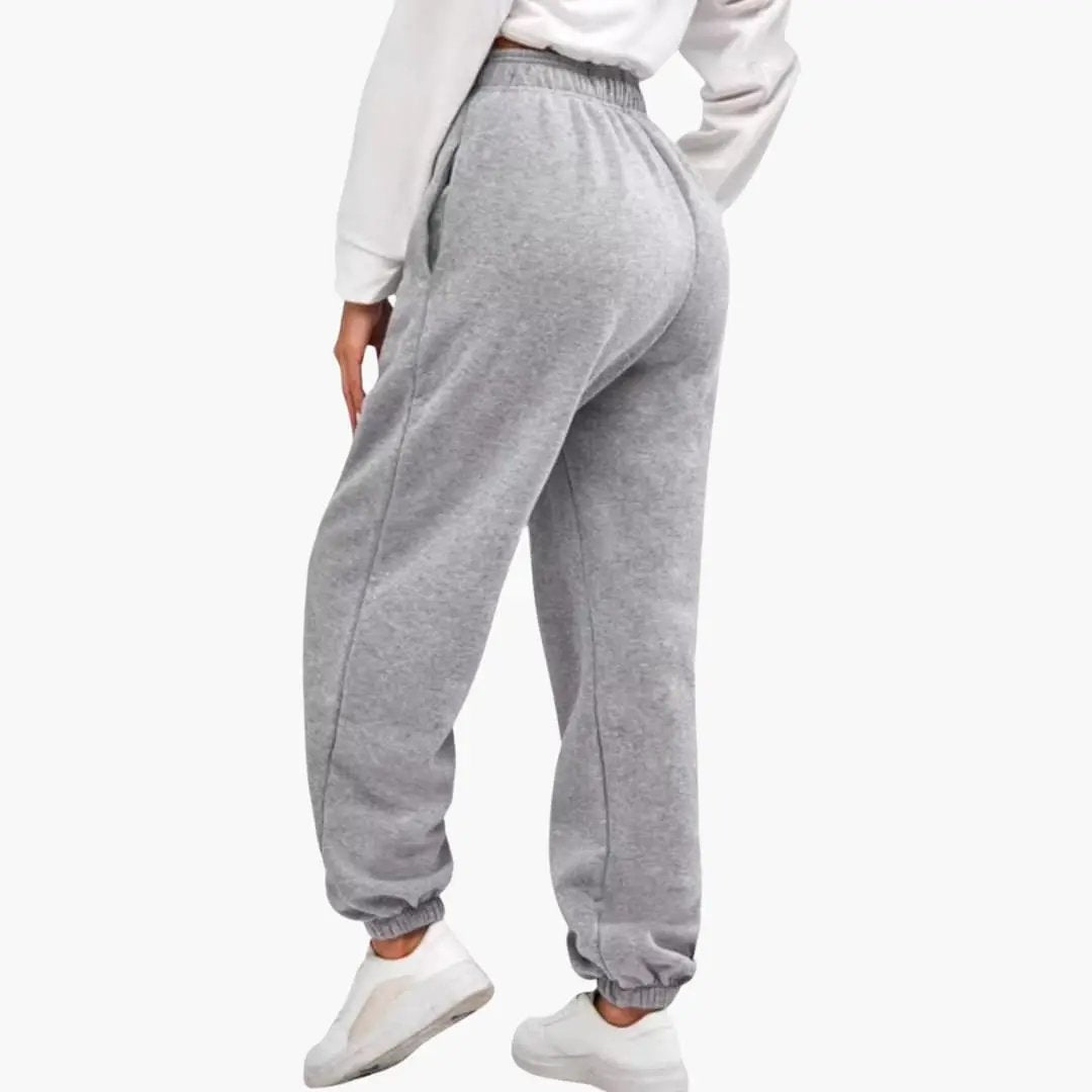 Women’s high-waist grey joggers with elastic waistband and cuffs, back view.