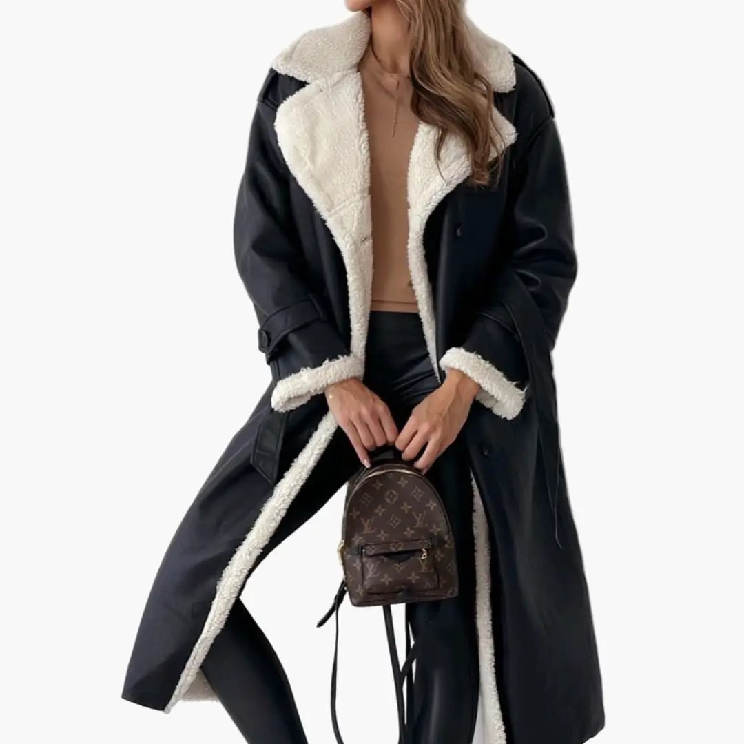 Women’s long black overcoat with lapel collar and cream shearling trim by Wilfred Smith