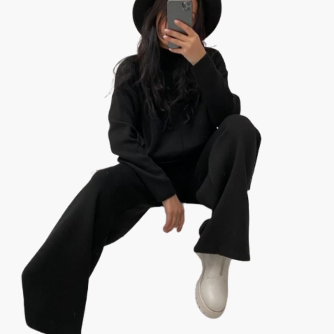 Women's loungewear set with black sweater and wide-leg pants, model wearing white boots.