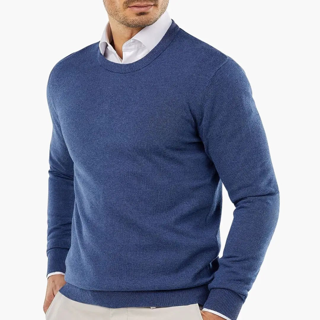 Men's blue knitted sweater with crew neck and long sleeves, worn over a white shirt.