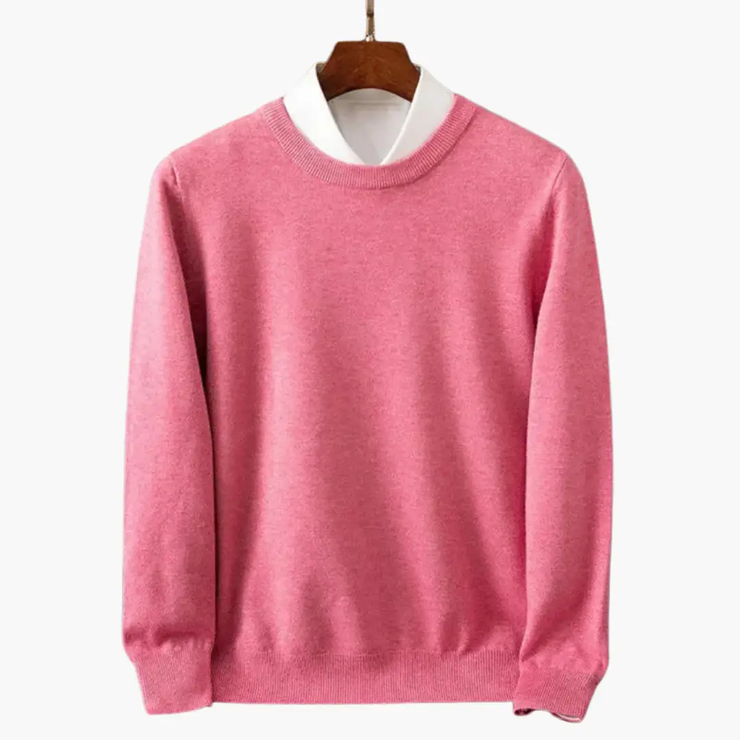 Pink men's crew-neck sweater with long sleeves and ribbed cuffs and hem, worn over a white shirt.