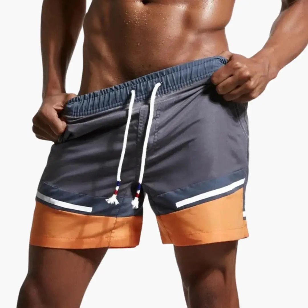 Men’s swim shorts with drawstring; gray navy body with orange hem and white stripe trim