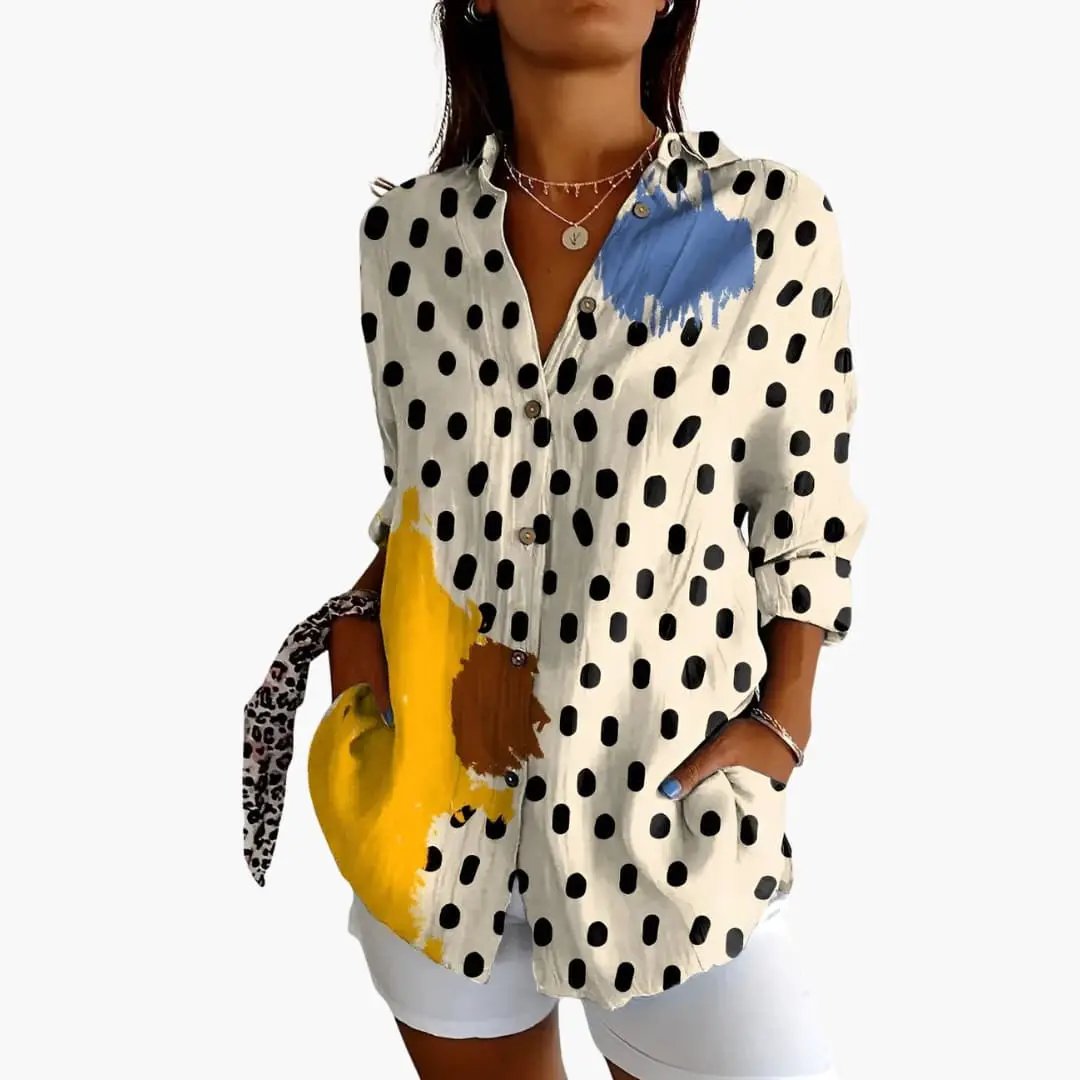 Women’s Printed Blouse with black polka dots on cream, featuring blue and yellow abstract paint accents; loose fit top.