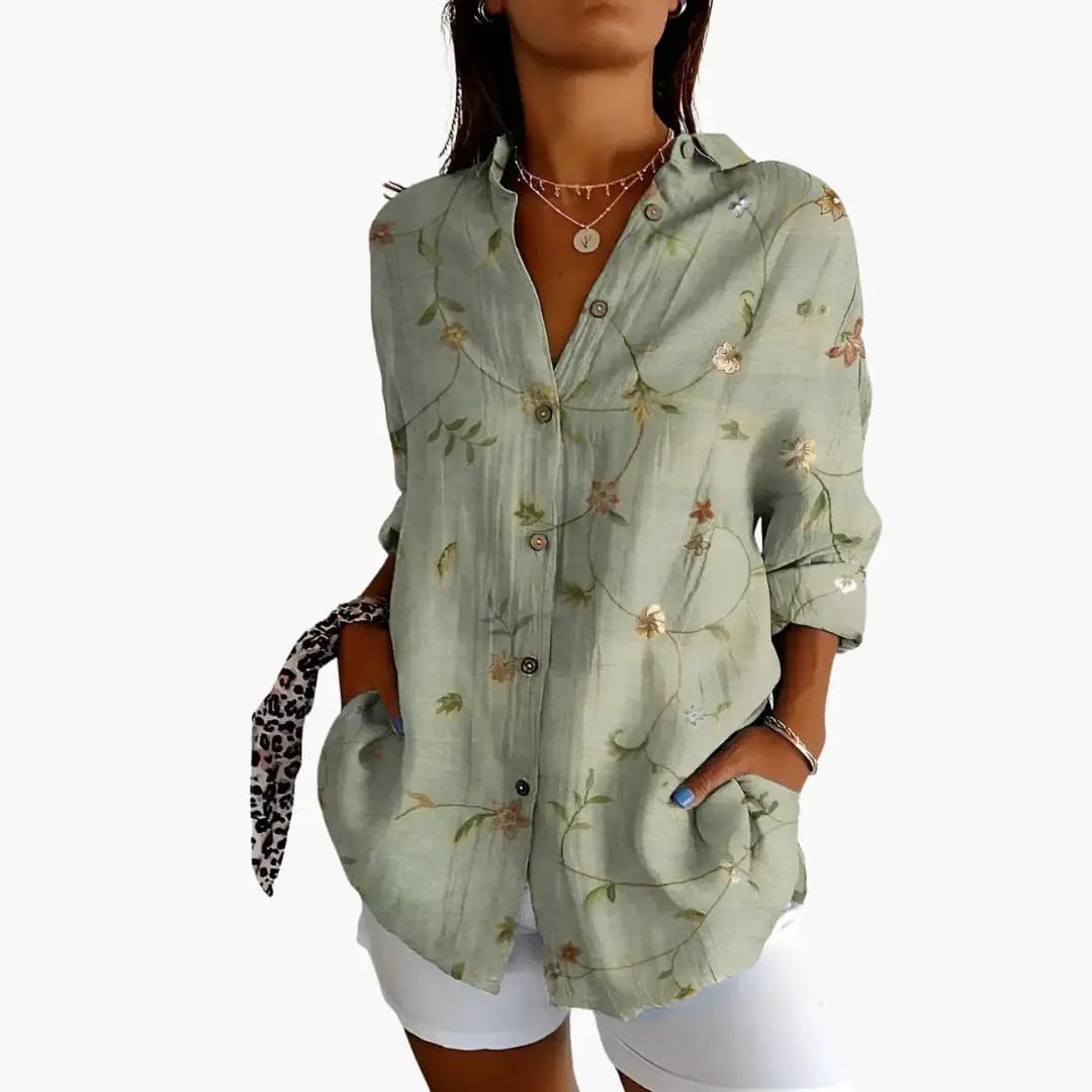 Women's printed blouse in sage green with floral pattern, button-down, loose-fit with rolled sleeves.
