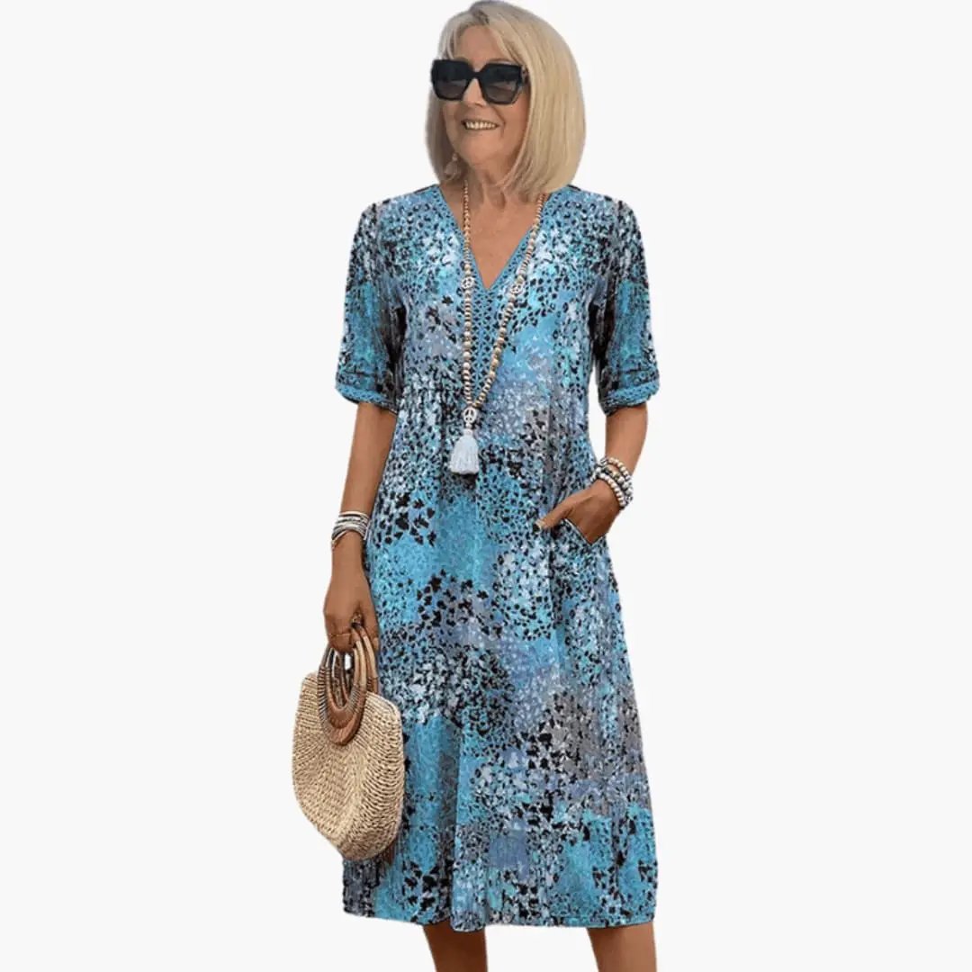 Women's printed V-neck midi dress with short sleeves in blue abstract pattern, loose fit.