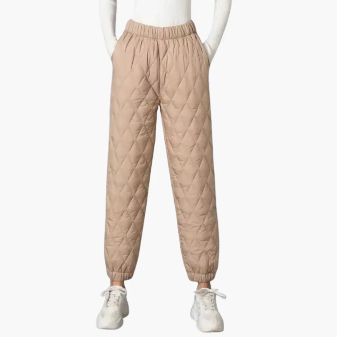 Women's quilted jogger trousers in tan with elastic waist and cuffed hems.