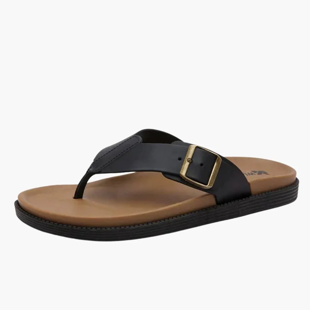 Women's Sandals by Wilfred Smith with cushioned insole, black strap, and gold buckle on a tan footbed.