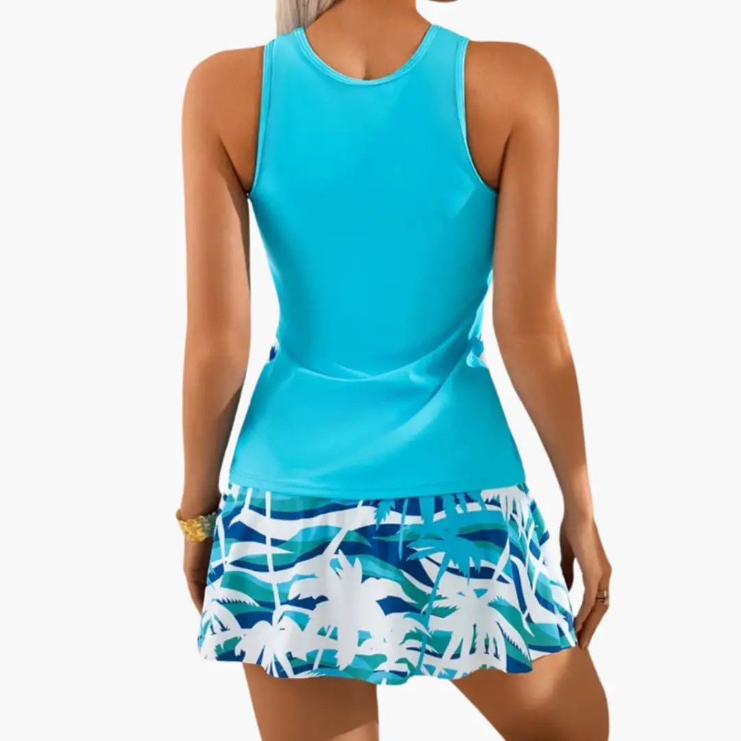 Women’s skirted tankini swimsuit with built-in bust support; turquoise top and palm-print skirt bottom