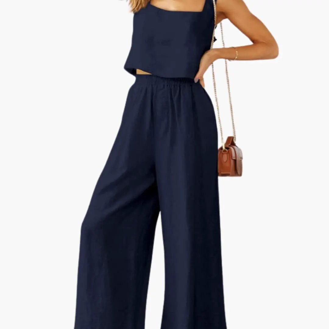 Two-piece navy outfit: square-neck crop top and wide-leg pants, with a brown crossbody bag.