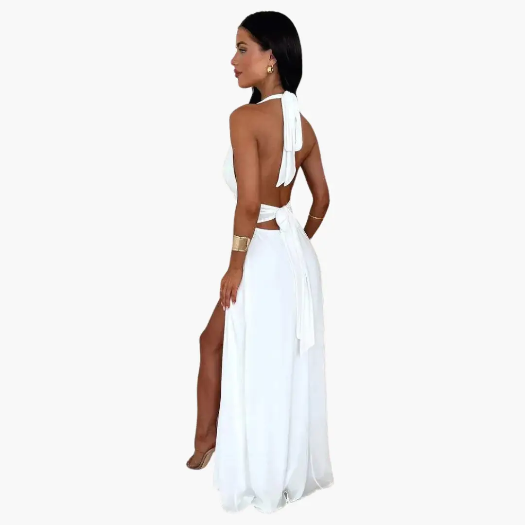 Halter-neck white maxi dress with open back, waist tie, and thigh-high slit
