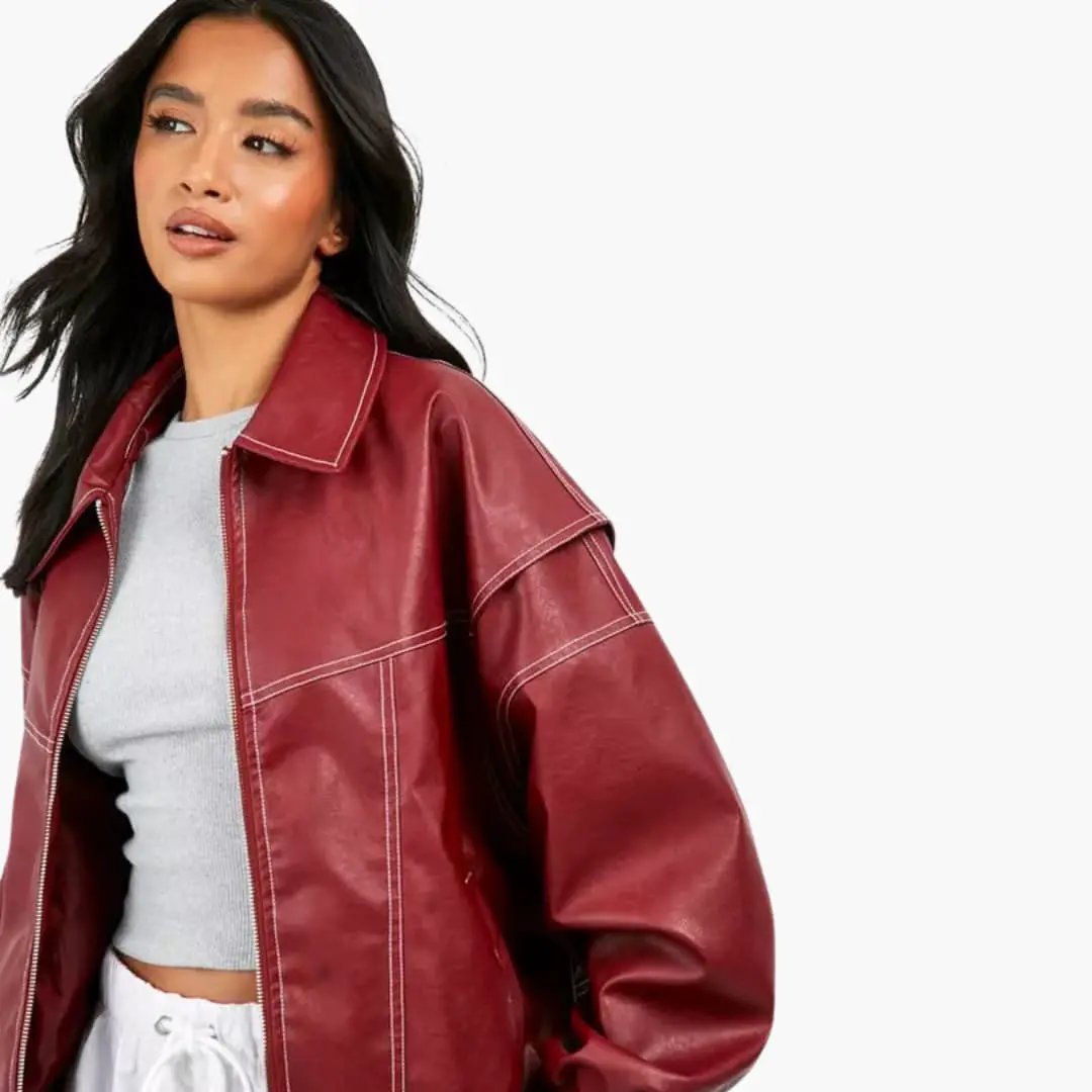 Women's oversized red faux leather trucker jacket with white contrast stitching.