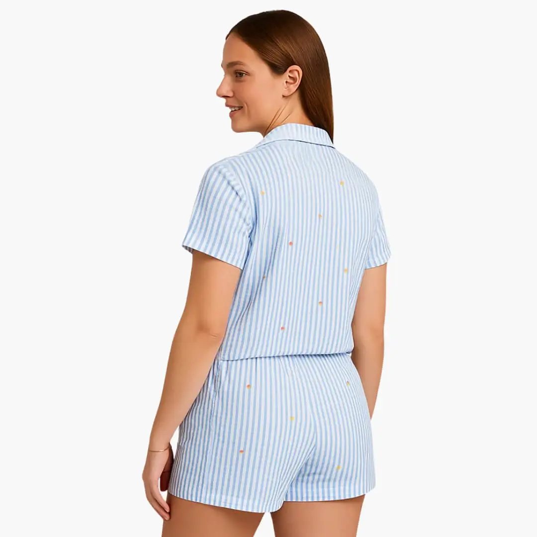 Women's pajama set with short-sleeve shirt and shorts; light blue striped fabric with small orange dots