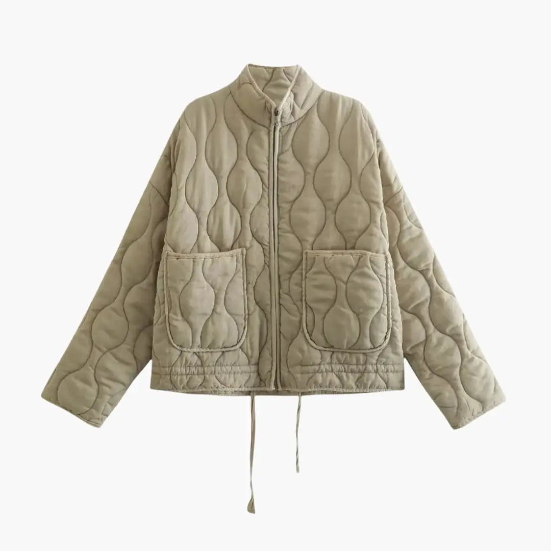 Women's beige quilted jacket with zip front, two large patch pockets, and adjustable hem drawstrings.