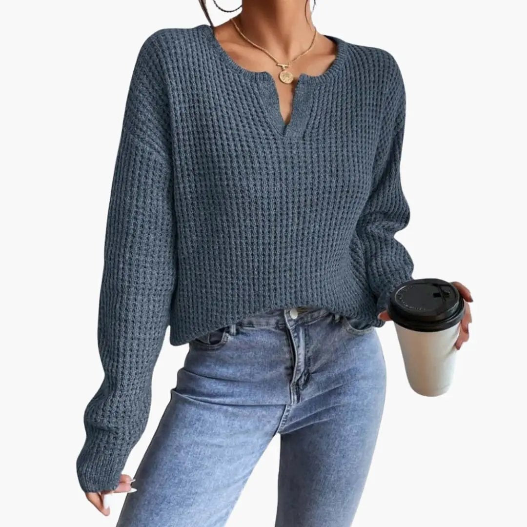 Women's blue knit sweater with a slit neckline, long sleeves, chunky waffle knit
