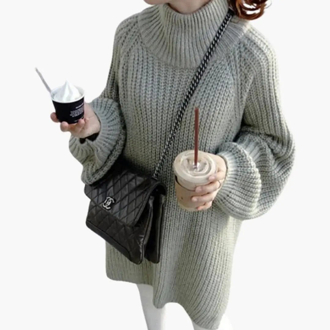 Women's oversized gray knit sweater with round neck, paired with a Chanel quilted bag.