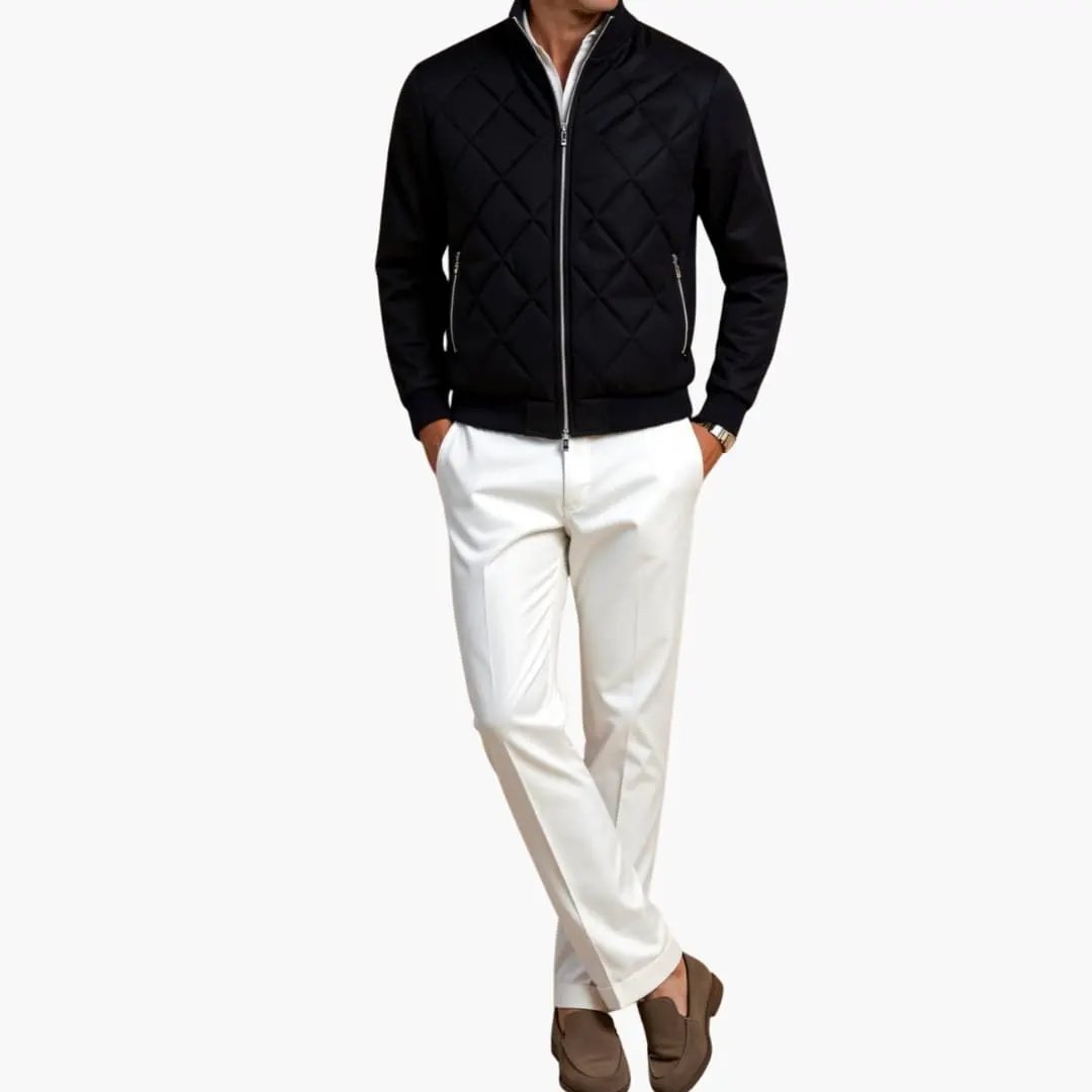 Men's black quilted zip jacket with diamond stitching; model wearing white pants