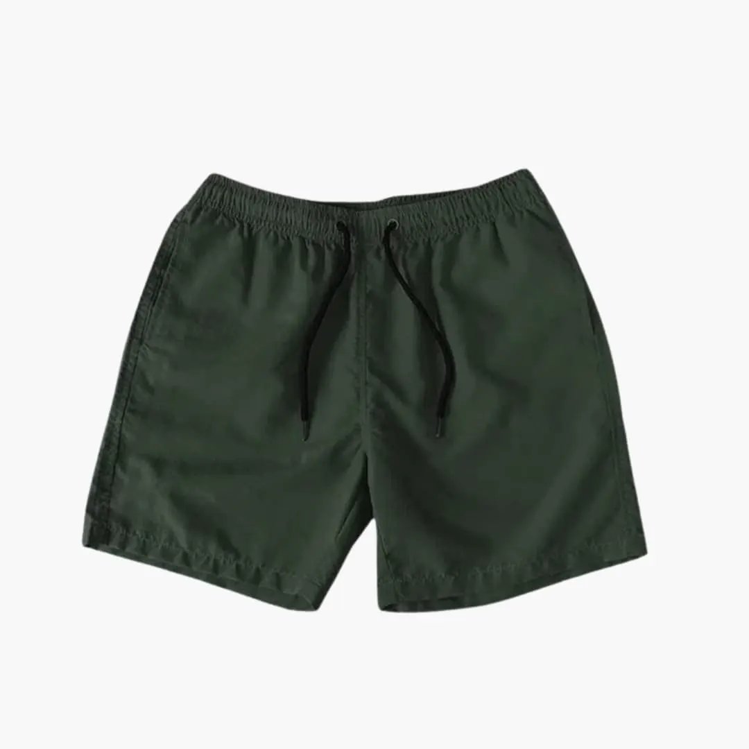 Men's knee-length jogger shorts in dark green with drawstring waist and zip pockets by Wilfred Smith