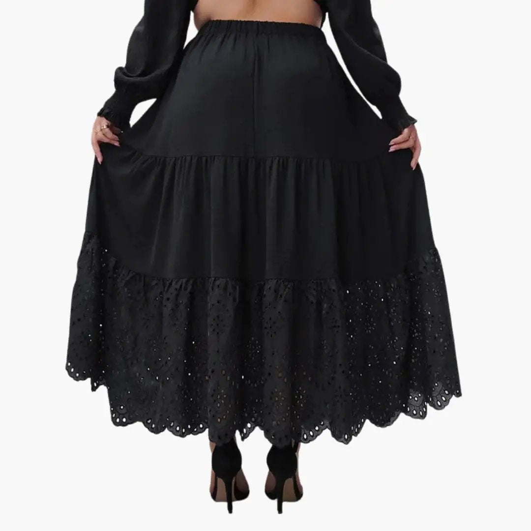 Women's black A-line maxi skirt with elastic waistband and eyelet lace hem.