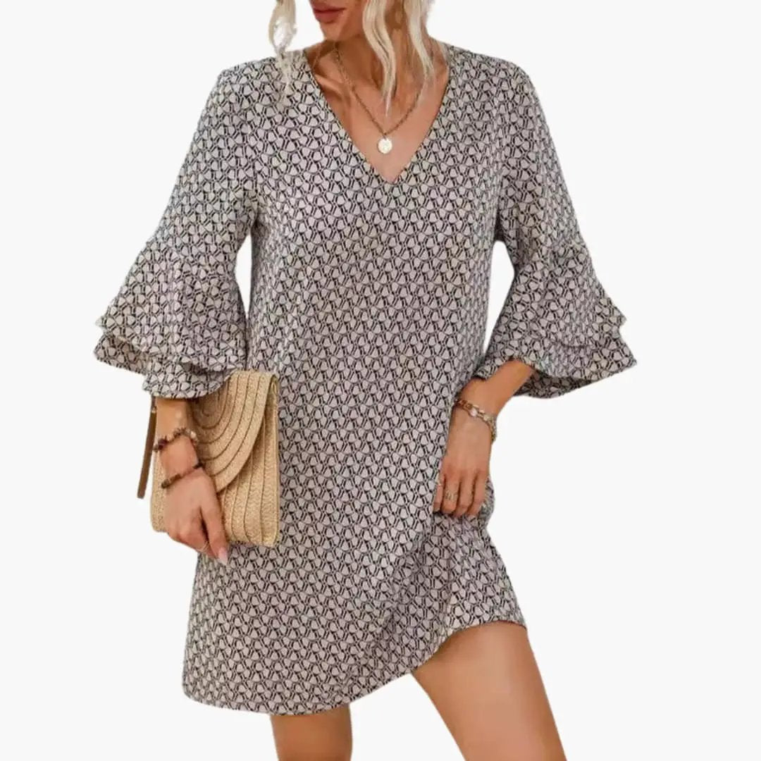 Women’s Beach Dress with V-neck and wide flutter sleeves in gray geometric print, paired with straw clutch