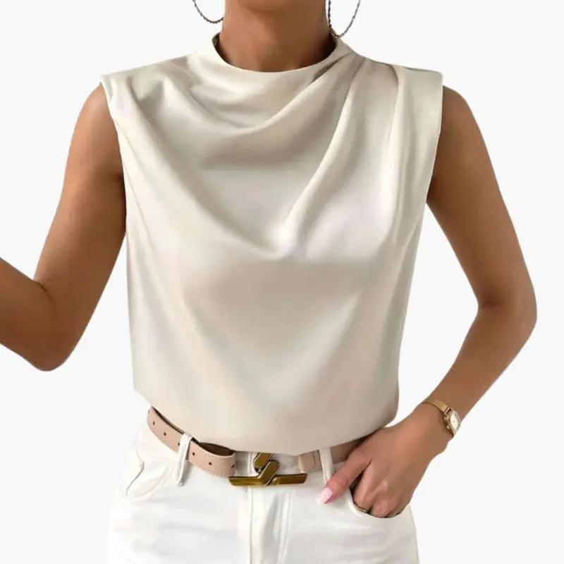 Women's sleeveless blouse in cream with round neckline, shown with white jeans and beige belt