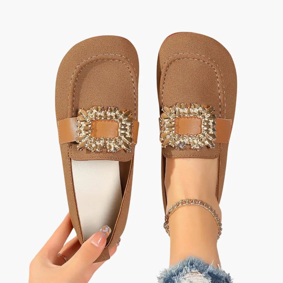 Two tan women's orthopedic loafers with decorative jeweled square buckles on straps, slip-on flats