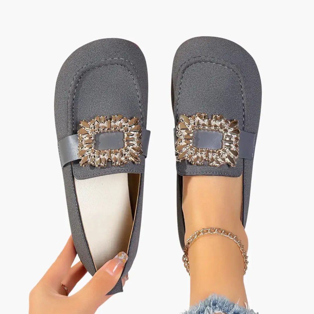 Pair of women's orthopedic flats: gray slip-on loafers with jeweled rectangular buckle.