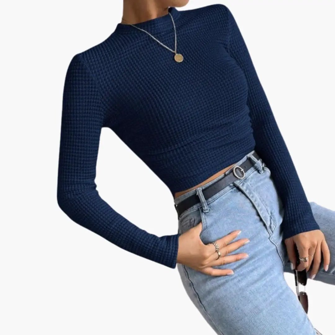 Women's ribbed long sleeve crop top in navy, paired with light-wash jeans.