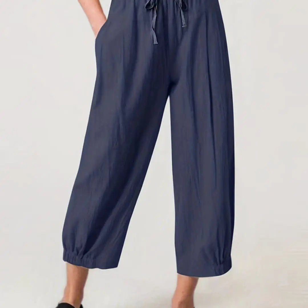 Women's navy blue cropped pants with elastic waistband and drawstring, pockets, and cuffed hems
