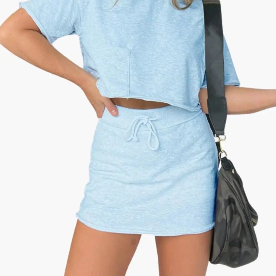 Women's two-piece set with crop top and drawstring waist skirt in light blue knit fabric.