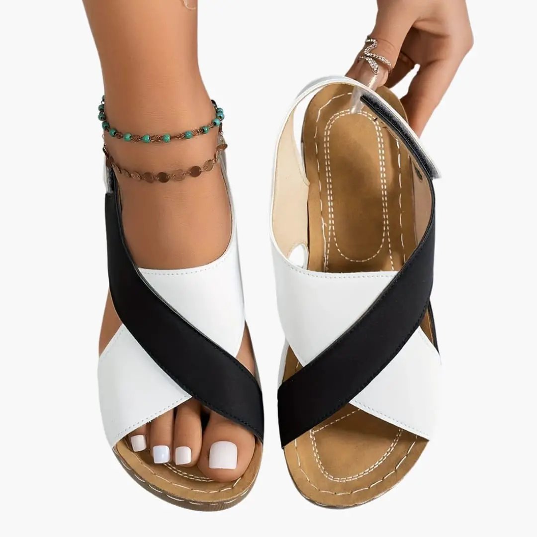 Pair of women's wedge sandals in white and black cross-strap design with cushioned footbed and platform sole.