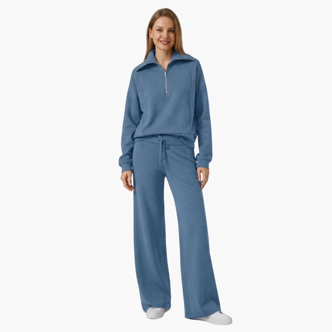 Women's two-piece lounge set in blue by Wilfred Smith with half-zip top and wide-leg pants.